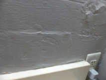 Subway tile effect in plaster. Poor finish in a past repair job. Filled soap holder